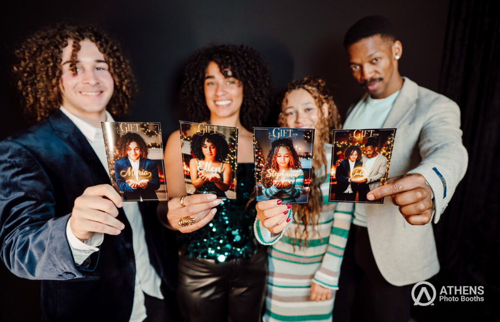 Guests holding holiday photo booth prints